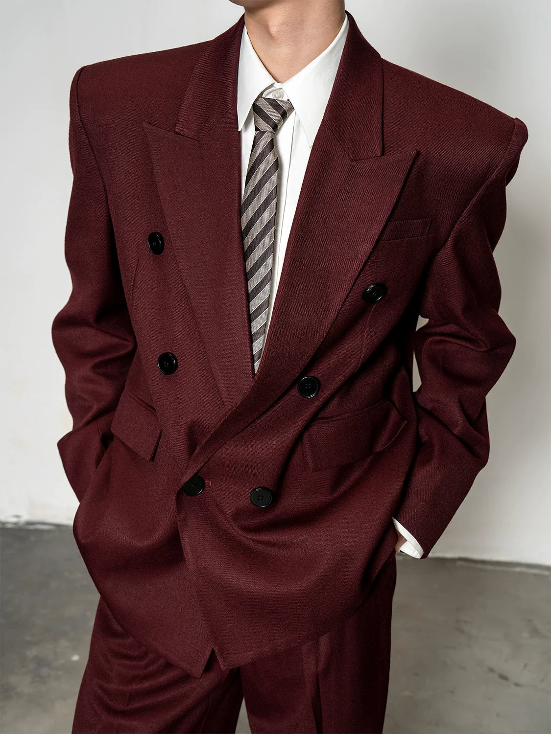 고급 울 소재의 오버숄더 재킷과 넉넉한 핏의 와이드 팬츠로 구성된 남성용 투피스 세트입니다.